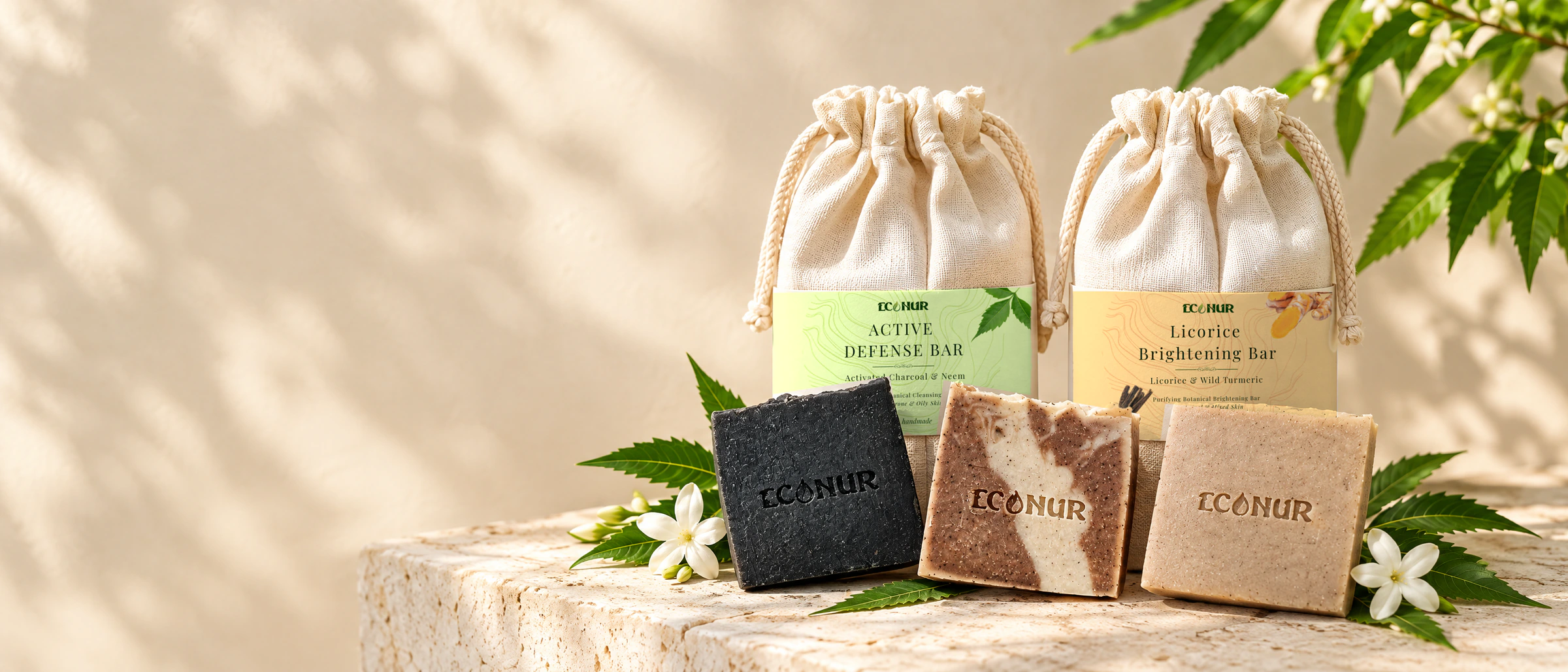 ECONUR handmade botanical soap bars and cotton pouches on a stone stand
